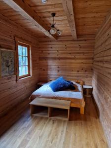 a bedroom with a bed in a wooden room at Sodyba Vovierių slėnis in Kuras