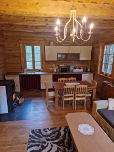 a living room with a dining table and a kitchen at Sodyba Vovierių slėnis in Kuras