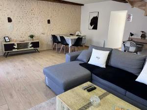 a living room with a blue couch and a table at La p'tite maison in Courgains