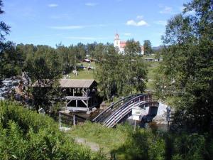 a bridge over a river with a building and trees at Sörmons Stugby in Ljusnedal