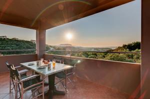 a table and chairs on a balcony with a view at Villas Almyrida in Almyrida