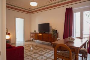 a living room with a tv and a wooden table at Casa Martù in Palermo