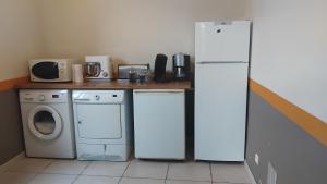 a kitchen with a refrigerator and a washing machine at Gîtes Les Clairets - Normandie in Mortain