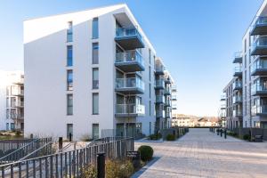 a white apartment building next to a sidewalk at The Hunt One in Dublin