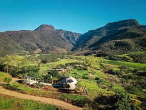 an aerial view of a farm with mountains in the background at Cabanas Malacara in Praia Grande