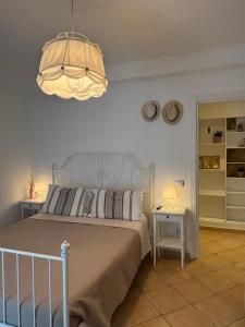 a bedroom with a bed and a chandelier at ValeHouse in Fiumicino