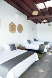 ein Schlafzimmer mit zwei Betten und zwei Uhren an der Wand in der Unterkunft Barón de Huaura Hotel Boutique in Huaura + 19 Fotos