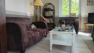 a living room with a couch and a table at Gîtes Les Clairets - Normandie in Mortain