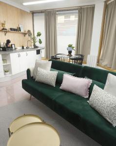 a green couch with pillows in a living room at Plaza de la Torre in Pontevedra