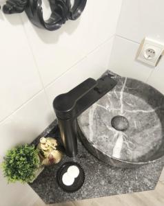 a sink with a faucet in a bathroom at Plaza de la Torre in Pontevedra +5 photos