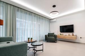 a living room with a couch and chairs and a tv at KAPA Luxury Living in Volos