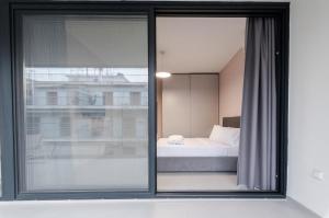 a bedroom with a view of a bed through a window at KAPA Luxury Living in Volos