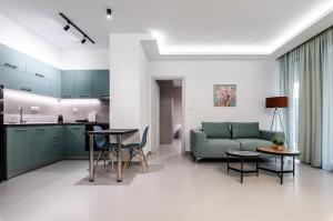 a living room with a green couch and a kitchen at KAPA Luxury Living in Volos
