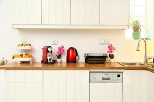 a kitchen with white cabinets and a wooden counter top at EMELIAS HOUSE SEA SIDE in Naxos Chora