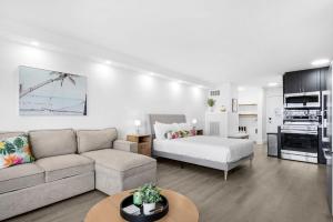 a living room with a couch and a bed at Renovated Beach Front Condo TOG 310 in Panama City Beach
