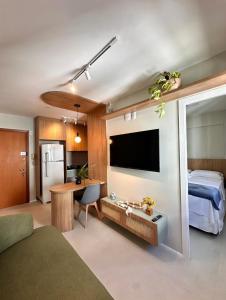 a bedroom with a bed and a desk with a television at Flat em Brasilia - Parque do Sudoeste in Brasília