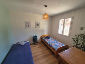 a bedroom with two beds and a table and a window at Lisière Hébergements - Casa Mouette Mouette in La Tremblade