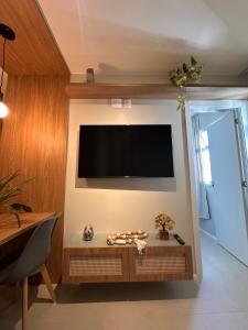 a living room with a flat screen tv on a wall at Flat em Brasilia - Parque do Sudoeste in Brasília +3 photos