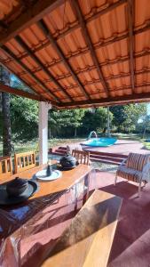 a patio with a table and chairs and a pool at Sitio Serra e Mar in Saquarema