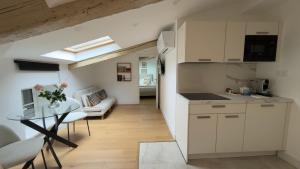 a kitchen and living room with a table and a couch at Situation exceptionnelle HARMONY III in Carcassonne