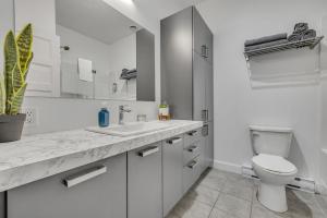 a white bathroom with a toilet and a sink at Initial Artsy Québec in Quebec City +29 photos