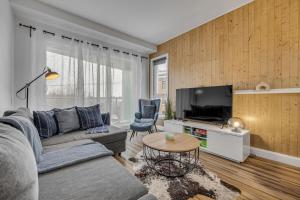 a living room with a couch and a tv at Initial Artsy Québec in Quebec City