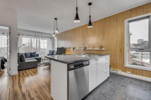 a kitchen with a sink and a living room at Initial Artsy Québec in Quebec City