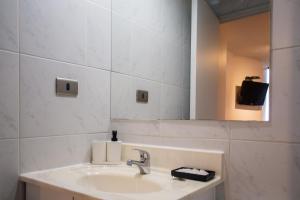 a bathroom with a sink and a mirror at Apart Hotel Plaza Centro in El Cerrillo