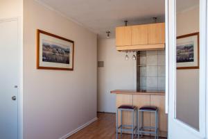 a kitchen with a counter and two stools at Apart Hotel Plaza Centro in El Cerrillo