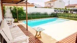 a swimming pool in a backyard with a table and a chair at Brisas Hosteria in Santa Clara del Mar