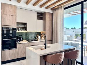 a kitchen with a counter with stools in it at Villa Ulysse 4 Bedroom Private Pool in Hammamet
