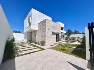 a large white brick house with a yard at Villa Ulysse 4 Bedroom Private Pool in Hammamet