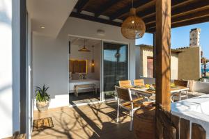 a patio with a table and chairs and a dining room at Theasea luxury retreat in Vrachonisída touArchangélou