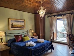 a bedroom with a blue bed with towels on it at Borgo Maggiore in Radicofani