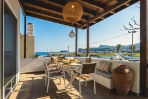 a dining room with a table and chairs on a balcony at Theasea luxury retreat in Vrachonisída touArchangélou