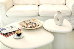 a white coffee table with a vase and a bowl of rocks at EMELIAS HOUSE SEA SIDE in Naxos Chora