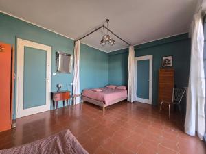 a bedroom with a pink bed and blue walls at Gîte bleu avec piscine chauffée couverte, Bozouls, Aveyron in Bozouls +21 photos