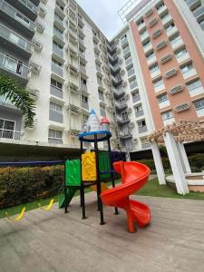 a playground in front of a large apartment building at Cozy unit in mivesa garden residence in Cebu City