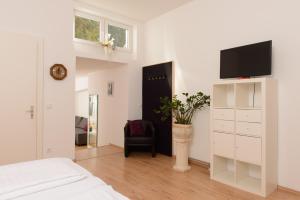 a bedroom with a bed and a tv and a chair at Hotel INNsel26 in Oberhausen