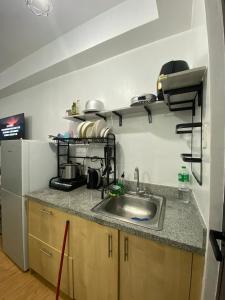 a kitchen with a sink and a counter top at Cozy unit in mivesa garden residence in Cebu City