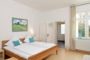 a bedroom with a bed with white sheets and blue pillows at Hotel INNsel26 in Oberhausen