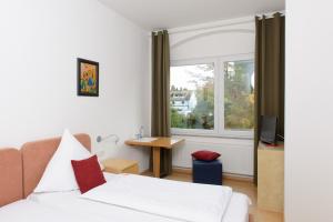 a bedroom with a bed and a window at Hotel INNsel26 in Oberhausen