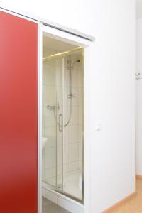 a shower in a bathroom with a glass door at Hotel INNsel26 in Oberhausen