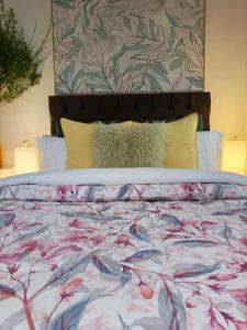 a bed with a colorful comforter and pillows at Qenqo's House in Cusco