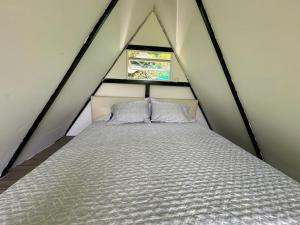 a bed with two pillows in a tent at Saray glamping in Palestina