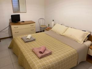 a bedroom with a bed with two towels on it at Matì 2 con navetta 25Eur in Lonate Pozzolo