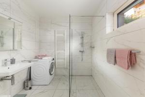 a white bathroom with a washing machine and a sink at Fine Stay Apartments in Žirovnica