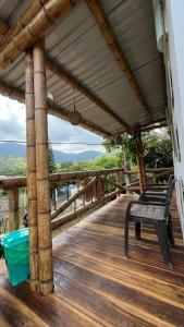 a porch with two benches on a wooden deck at Cabaña El Tucan in Minca