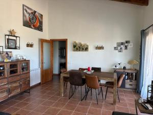a dining room with a wooden table and chairs at Can Roura in Rocabruna