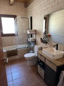 a bathroom with a toilet and a sink and a tub at Can Roura in Rocabruna +2 photos